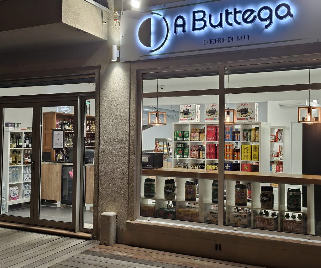 Photo de la vitrine de l'établissement, prise de nuit avec l'enseigne lumineuse